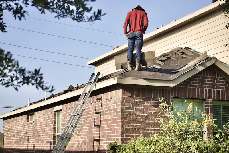 Professional roofer working on a residential roof in Quadrangle